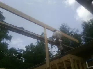 Carpenter setting a ridge beam over a new addition frame — Ice Dam Removal by Roofing Brothers in Dupo