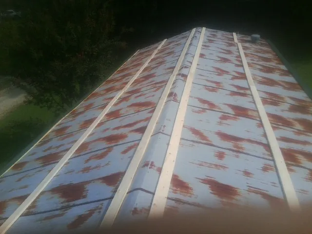 Rusted metal roof panels with new wood purlins before replacement — Storm Damage Roof Repair in Dupo by Roofing Brothers