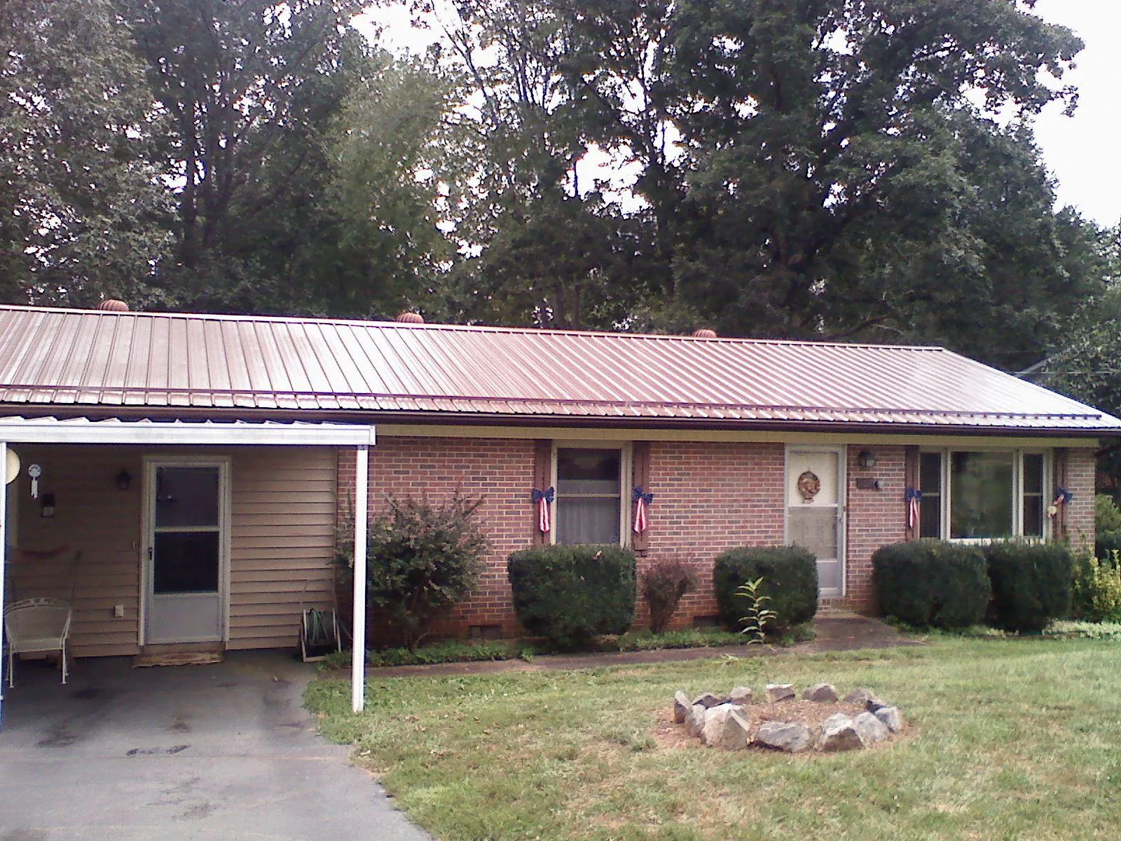 Bronze metal roof and carport on a brick ranch home — Roof Repair work by our crew in Dupo